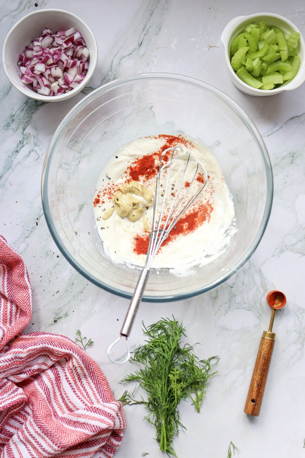 Whisking the 4th of July potato salad dressing with paprika streaked through the mayo