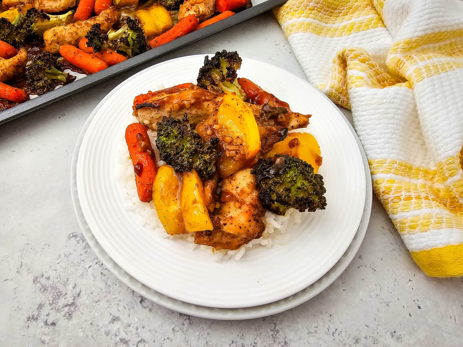 Closeup of a plate of honey garlic chicken and veggies on a white plate