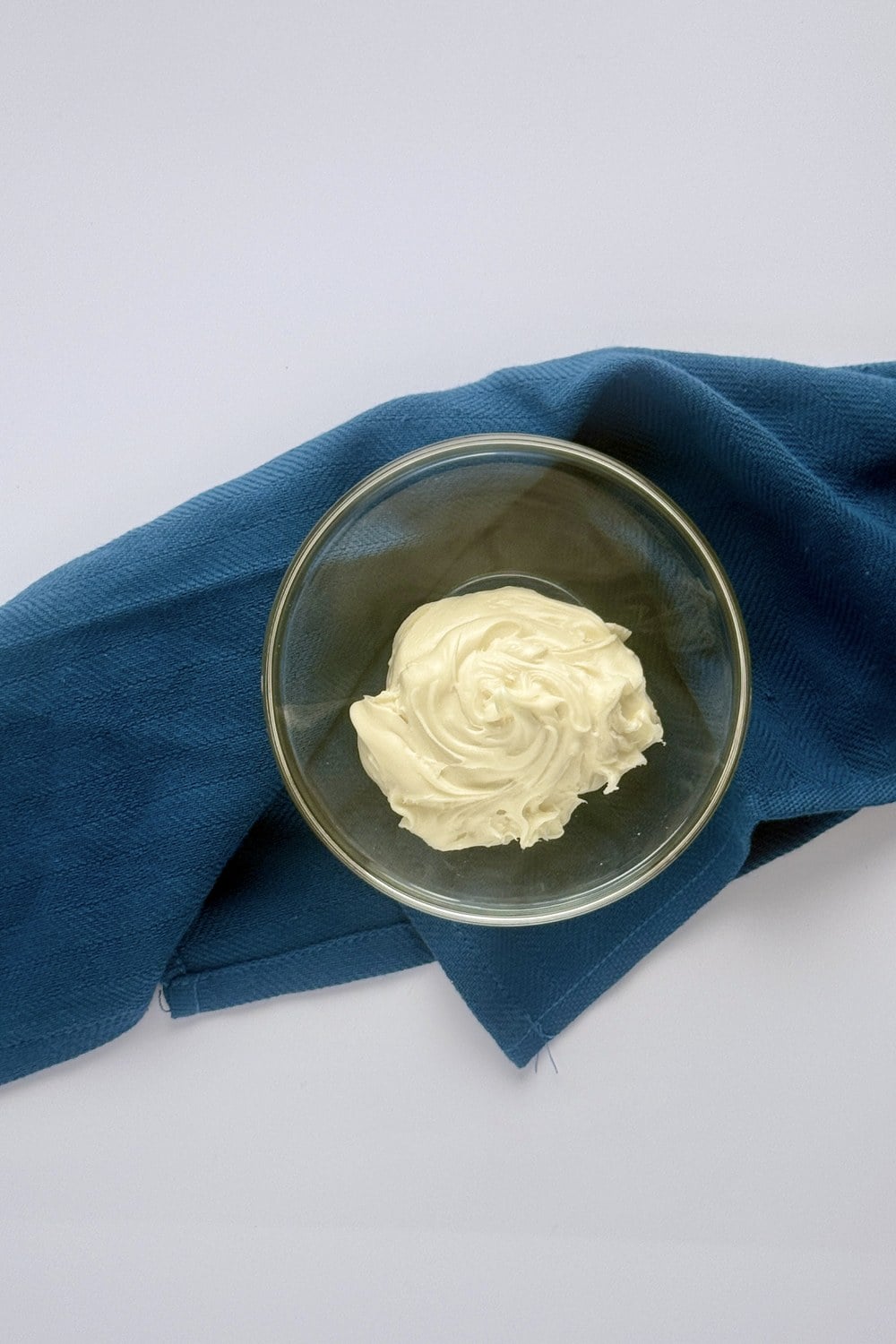 Plain white frosting in a glass bowl, the starting point for both methods