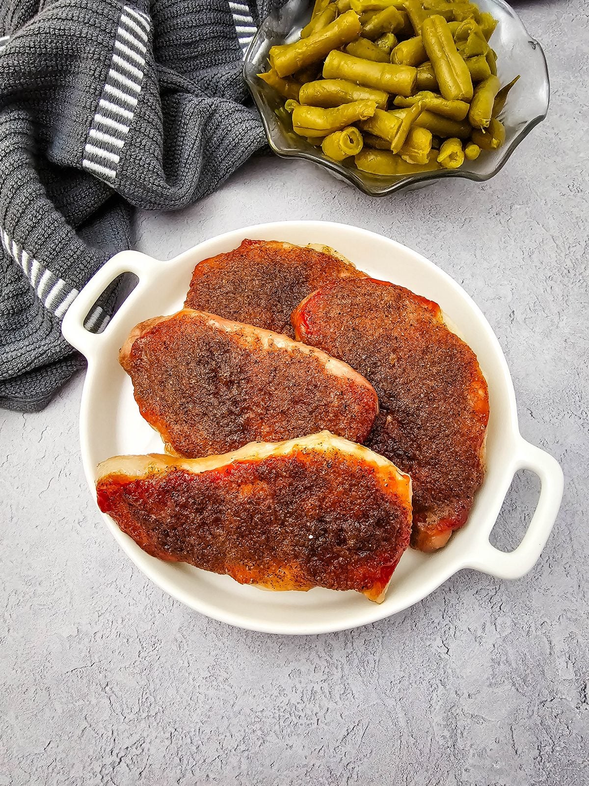 Brown sugar and ketchup pork chops on a plate with a caramelized glaze