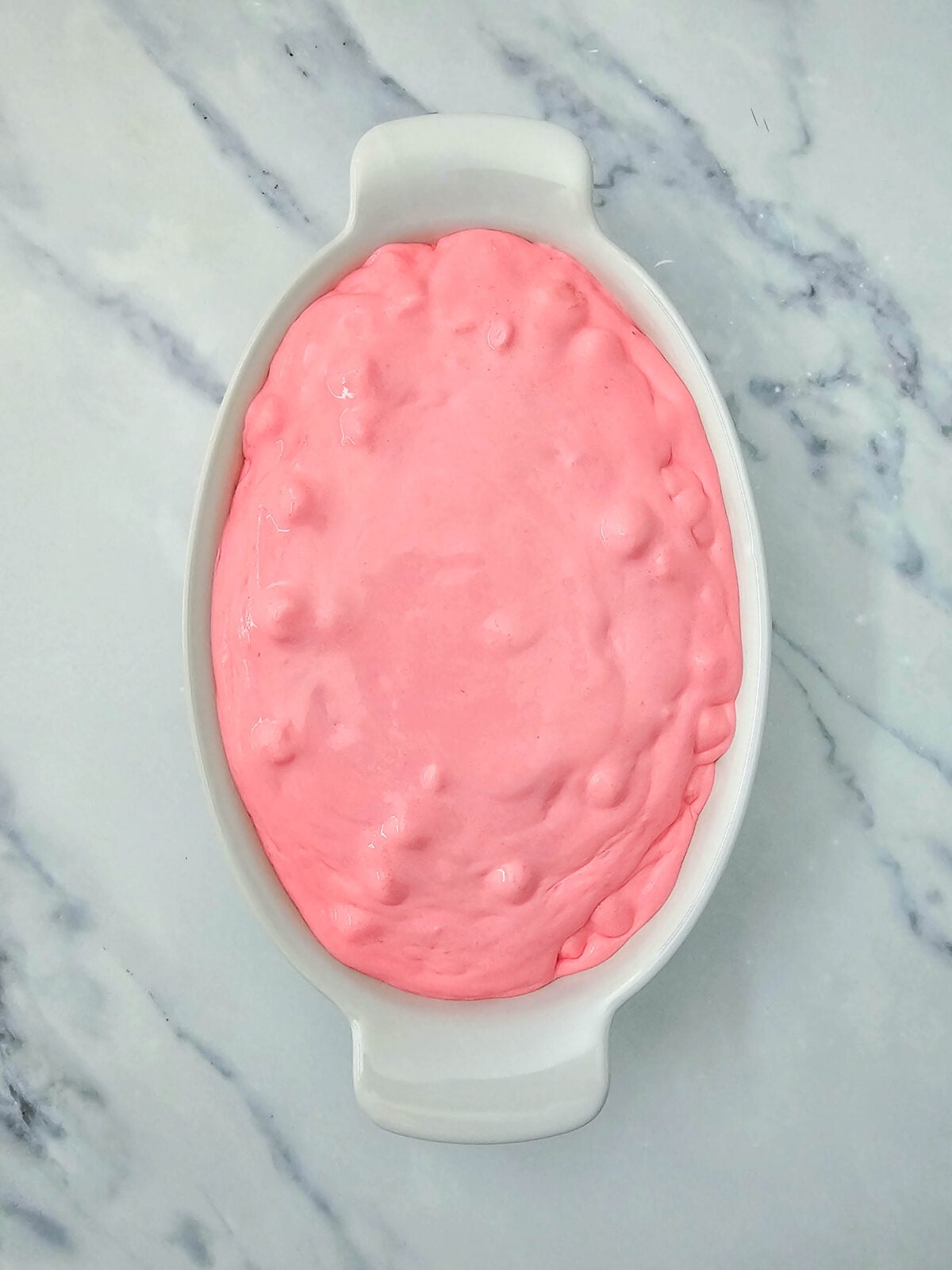 Finished pink fluff smoothed into a white oval serving dish, ready to chill