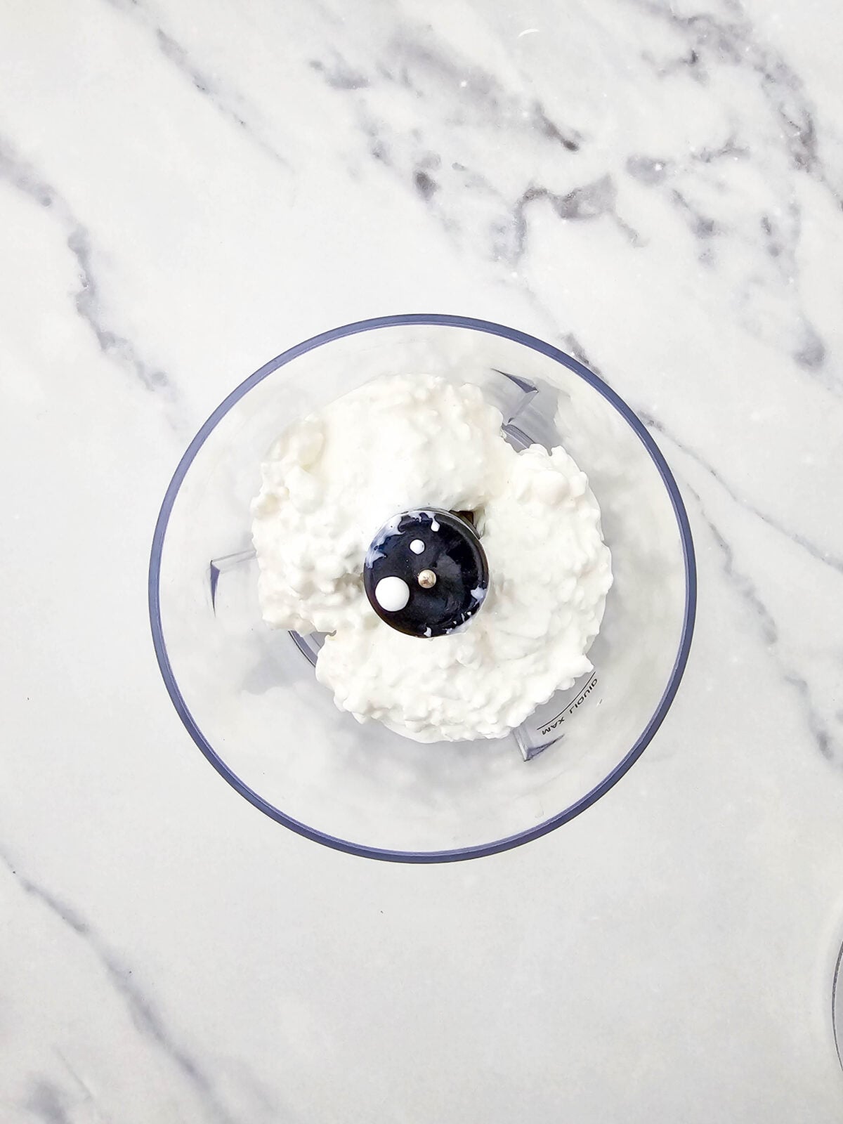 Cottage cheese curds added to a small food processor bowl