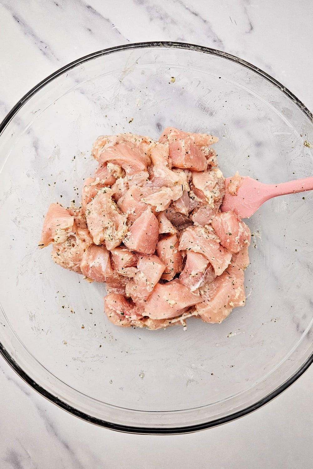 Chicken cubes tossed and fully coated in dry ranch seasoning, ready for the sheet pan.