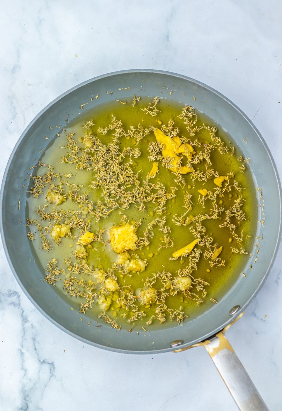 Maple glaze simmering in a pan with thyme and Dijon