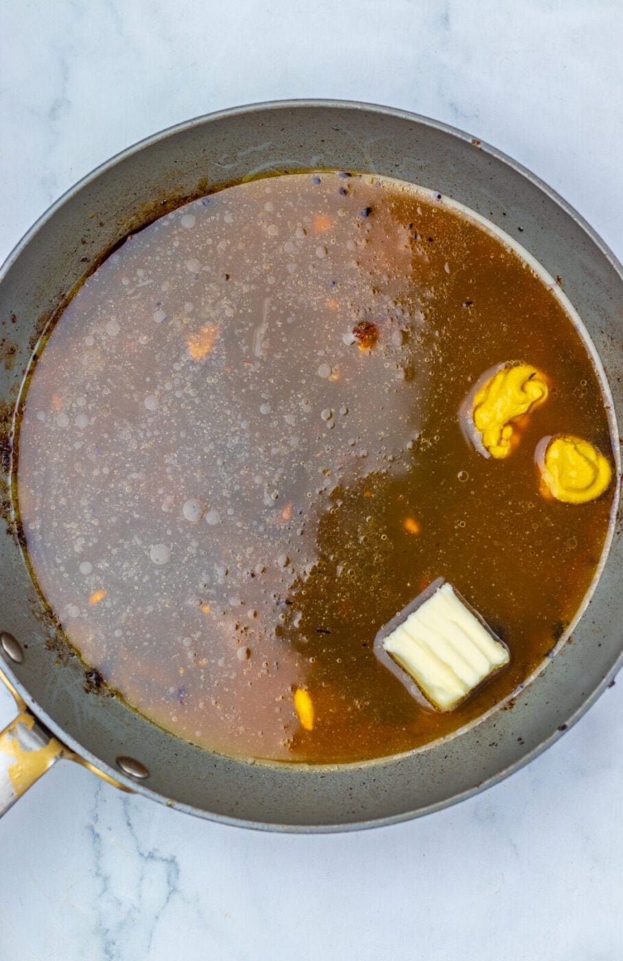 Apple cider, brown sugar and butter glaze cooking in a pan