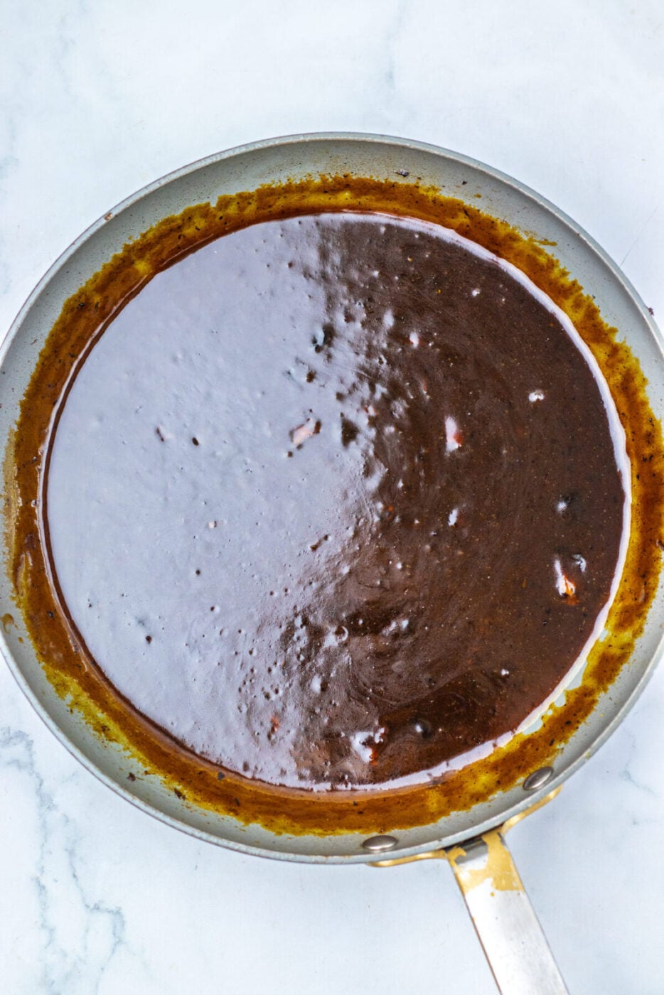 Thickened apple cider glaze in a skillet