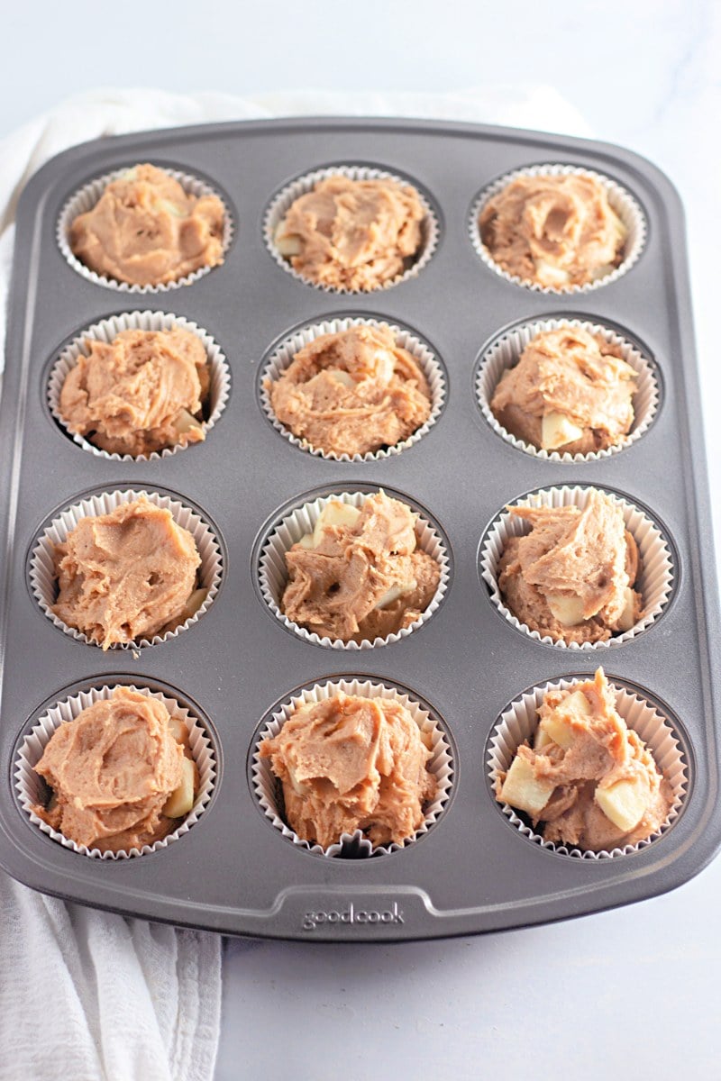 Apple cinnamon muffins filling muffin tin