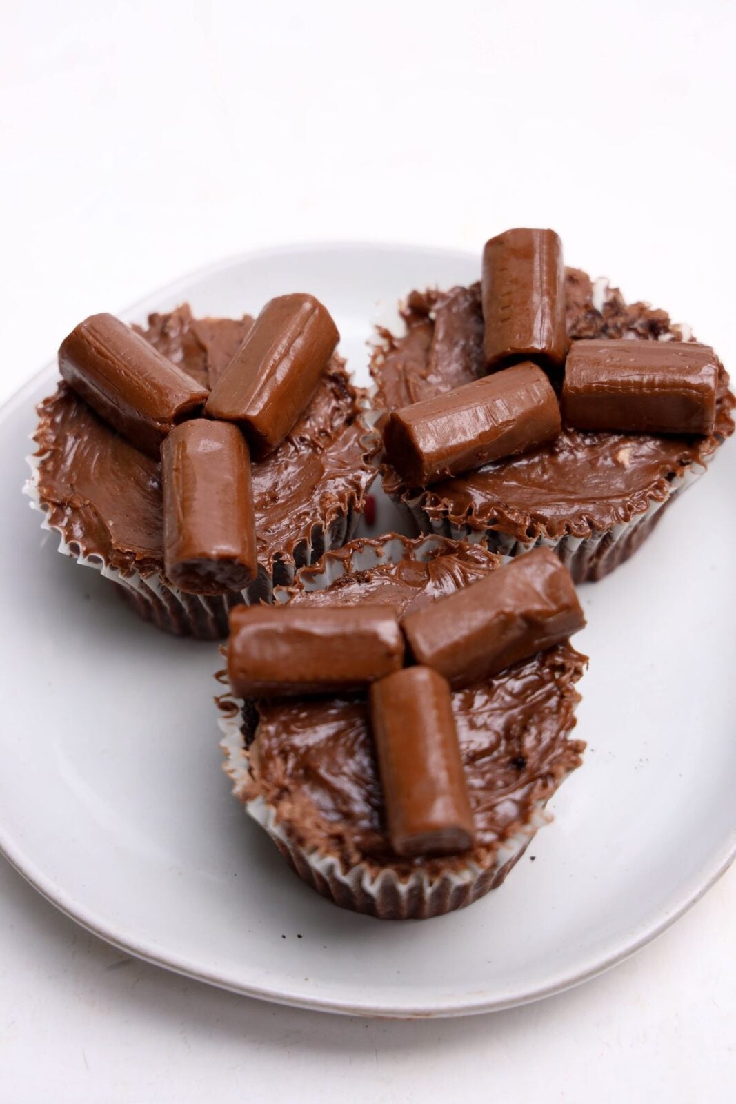 Tootsie Rolls arranged as logs on chocolate-frosted cupcakes