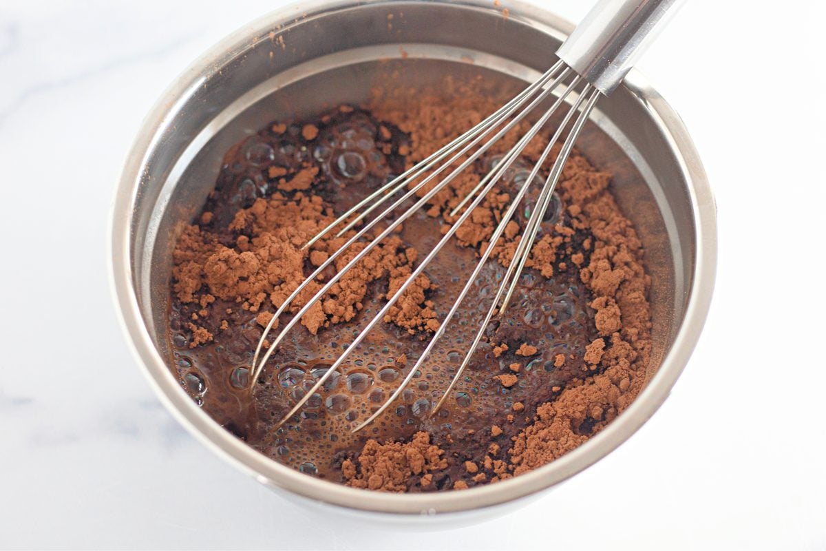 Cocoa powder whisked with boiling water in a bowl