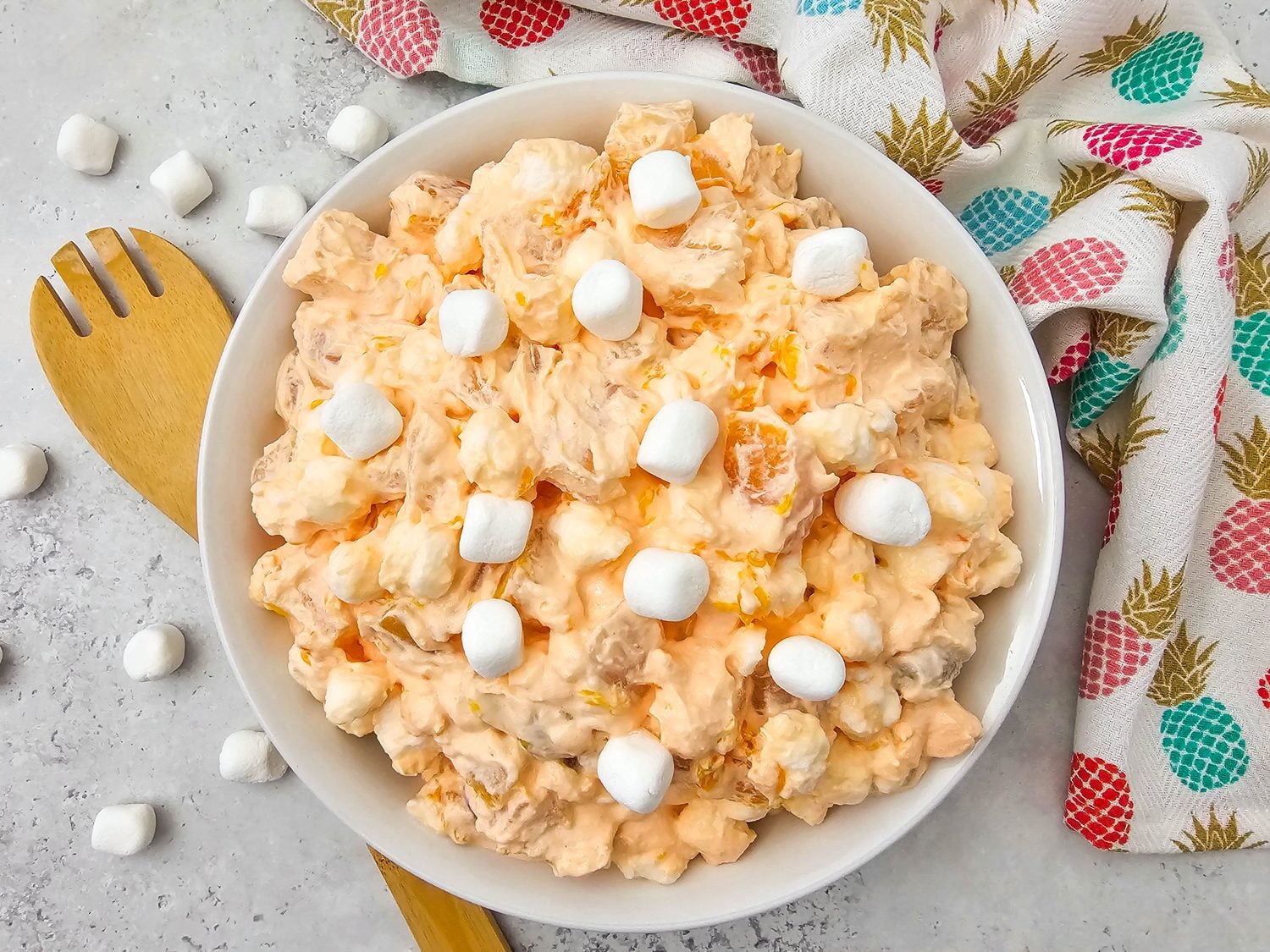 Overhead view of creamy Hawaiian fruit salad topped with mini marshmallows