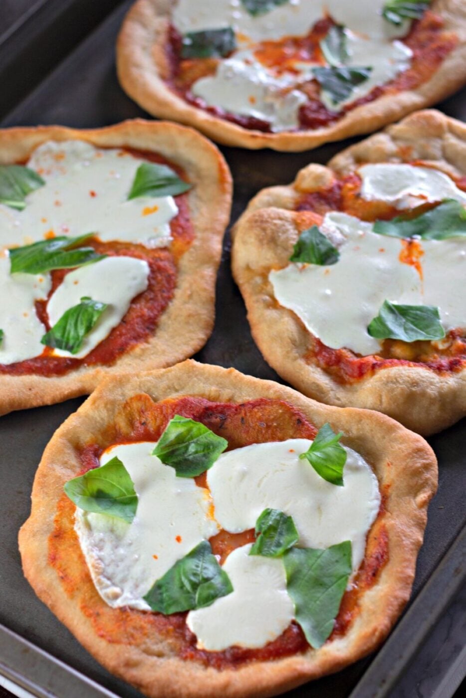 Baked fried pizza topped with mozzarella and fresh basil