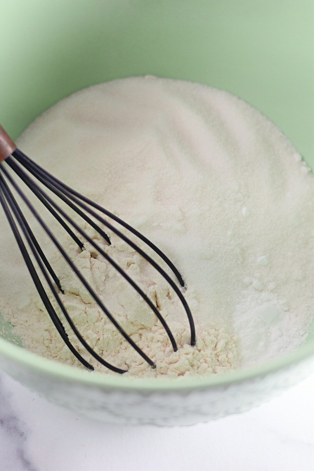 Combined dry ingredients for funfetti crazy cake in a mixing bowl