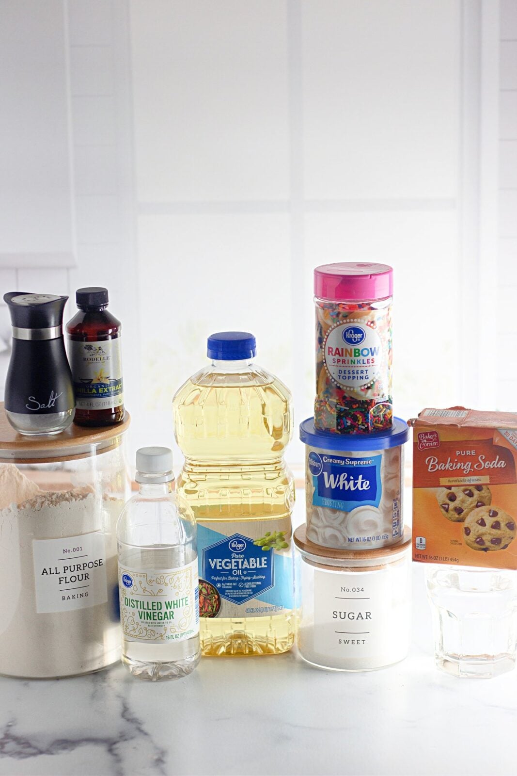 Ingredients for funfetti crazy cake laid out on a counter