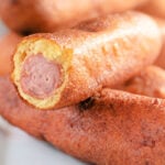 Corn dog cut open showing the hot dog inside the cornbread coating
