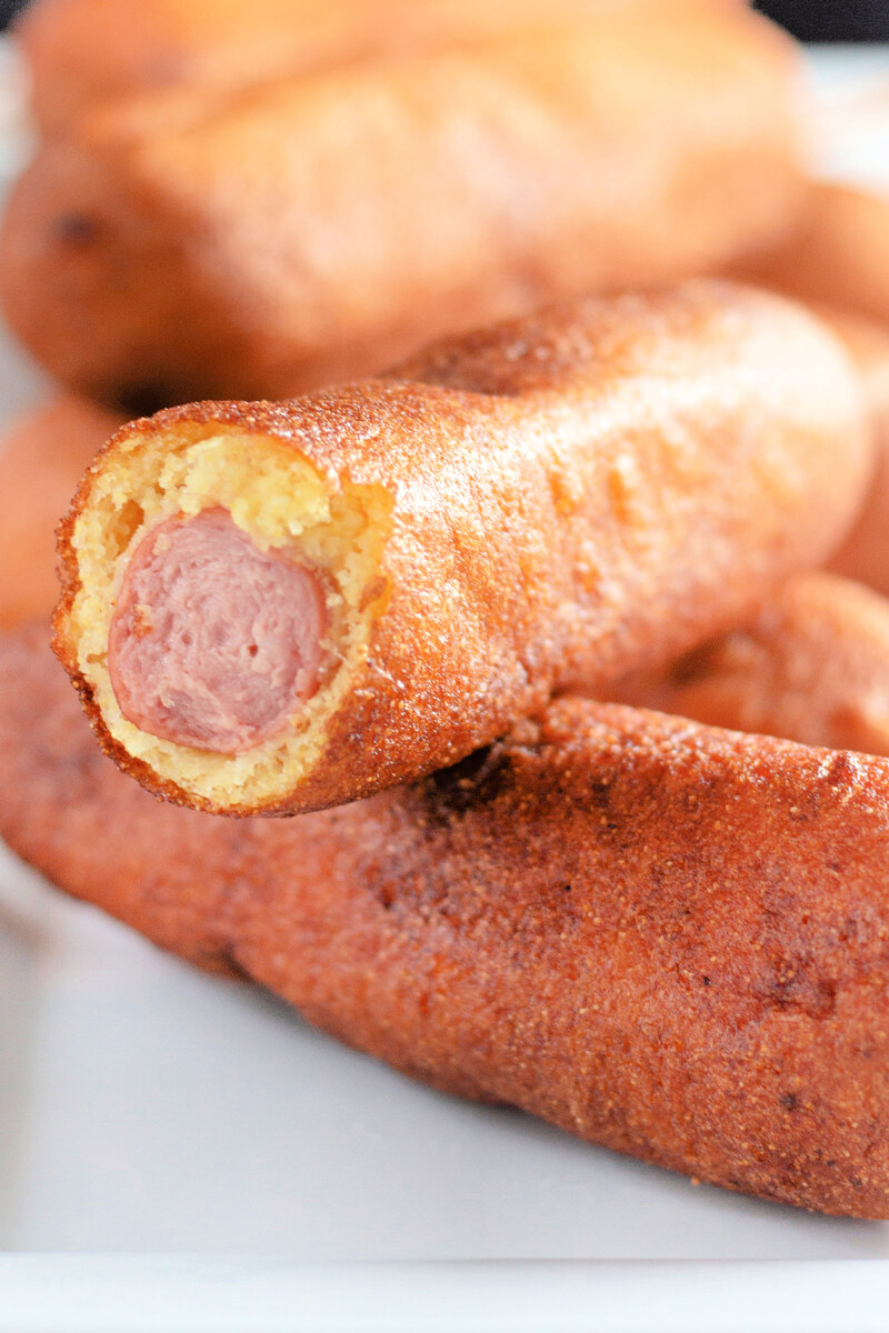 Corn dog cut open showing the hot dog inside the cornbread coating