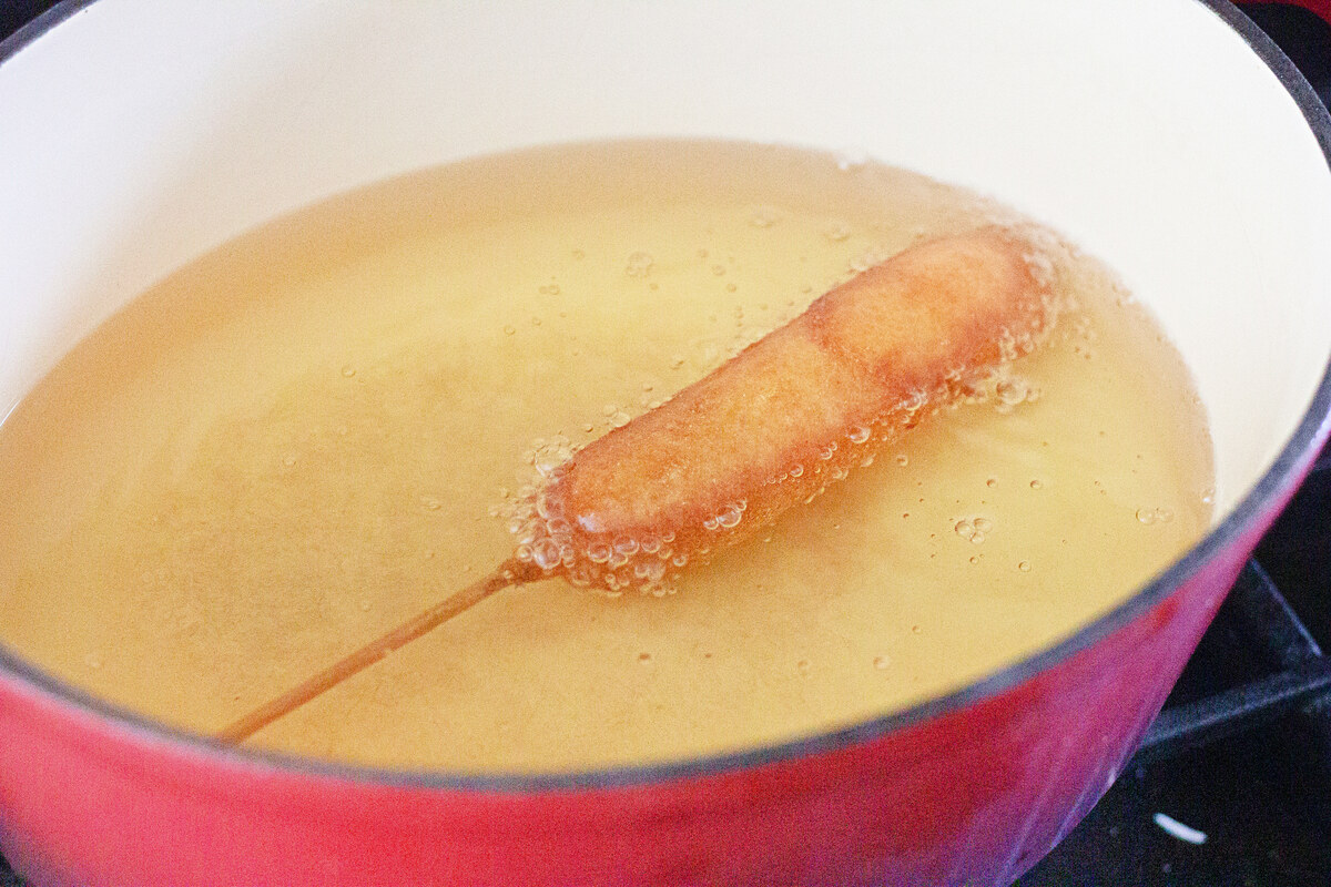 Golden brown corn dog frying in oil