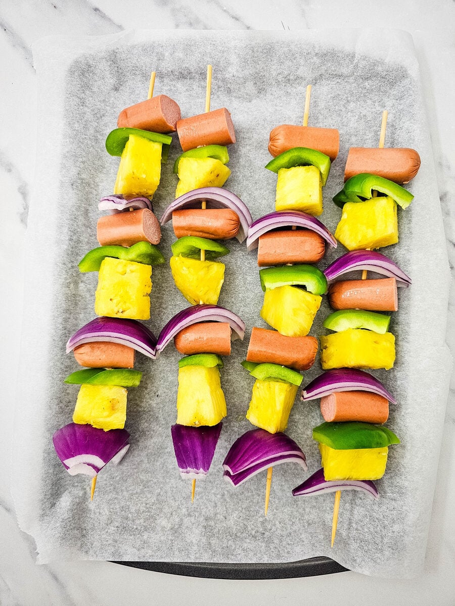 Assembled hot dog kabobs on parchment ready for the grill
