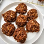 Classic no-bake cookies stacked on a white plate showing their chewy oat texture.