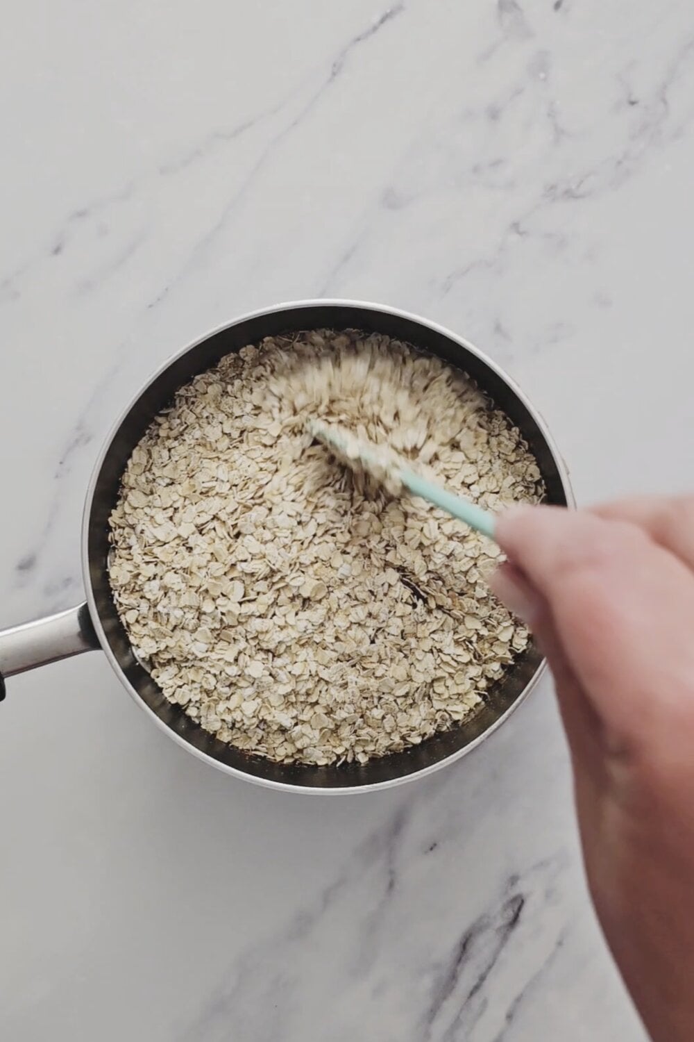 Quick oats being stirred into the chocolate peanut butter mixture.
