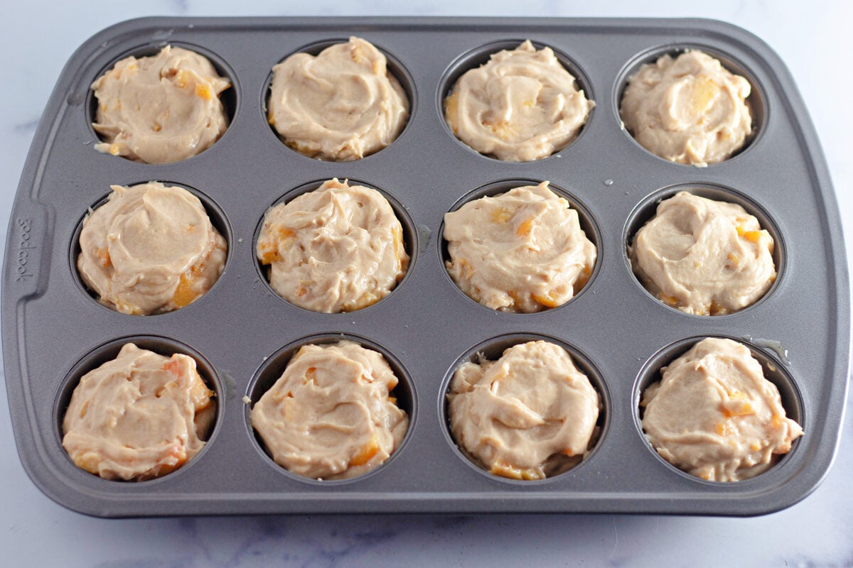 Peach streusel muffins fill muffin cups