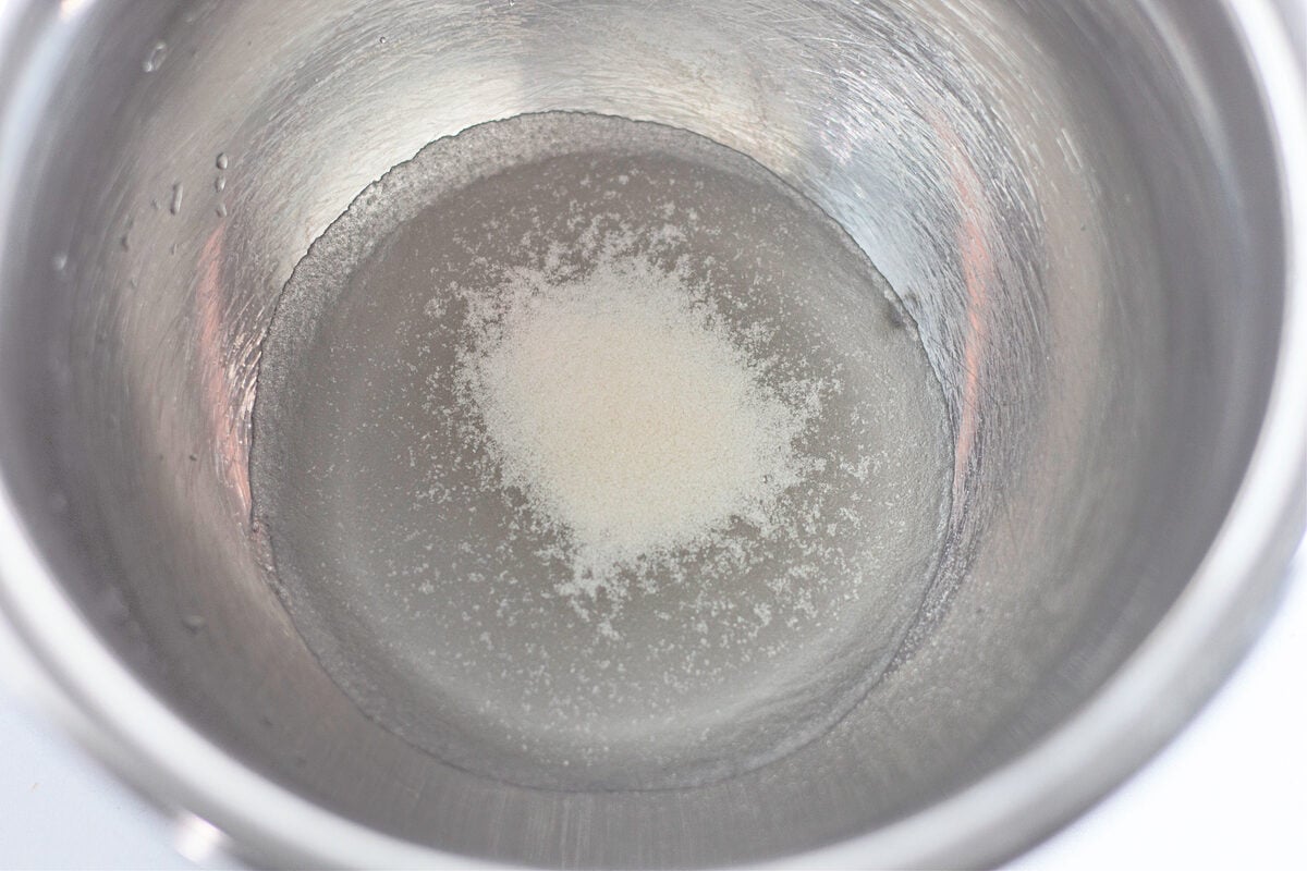 Beating heavy whipping cream and powdered sugar to soft peaks
