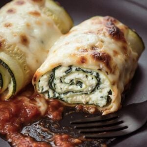 Zucchini rollatini cut open showing the ricotta and basil filling