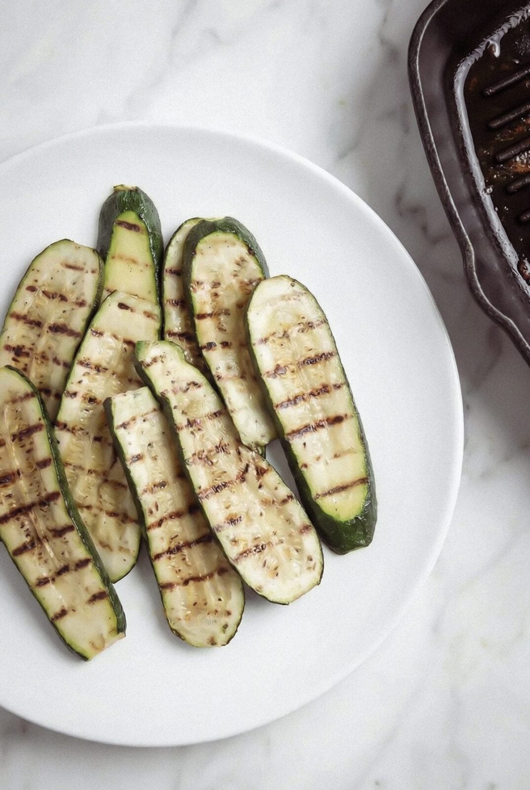 Grilled zucchini strips with grill marks on a plate