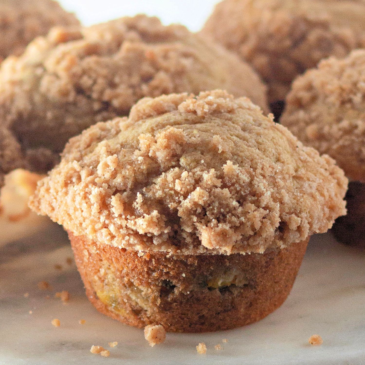 Closeup of homemade peach muffins with crumb topping