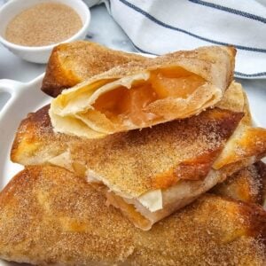 A stack of crispy apple pie filling egg rolls with cinnamon sugar coating