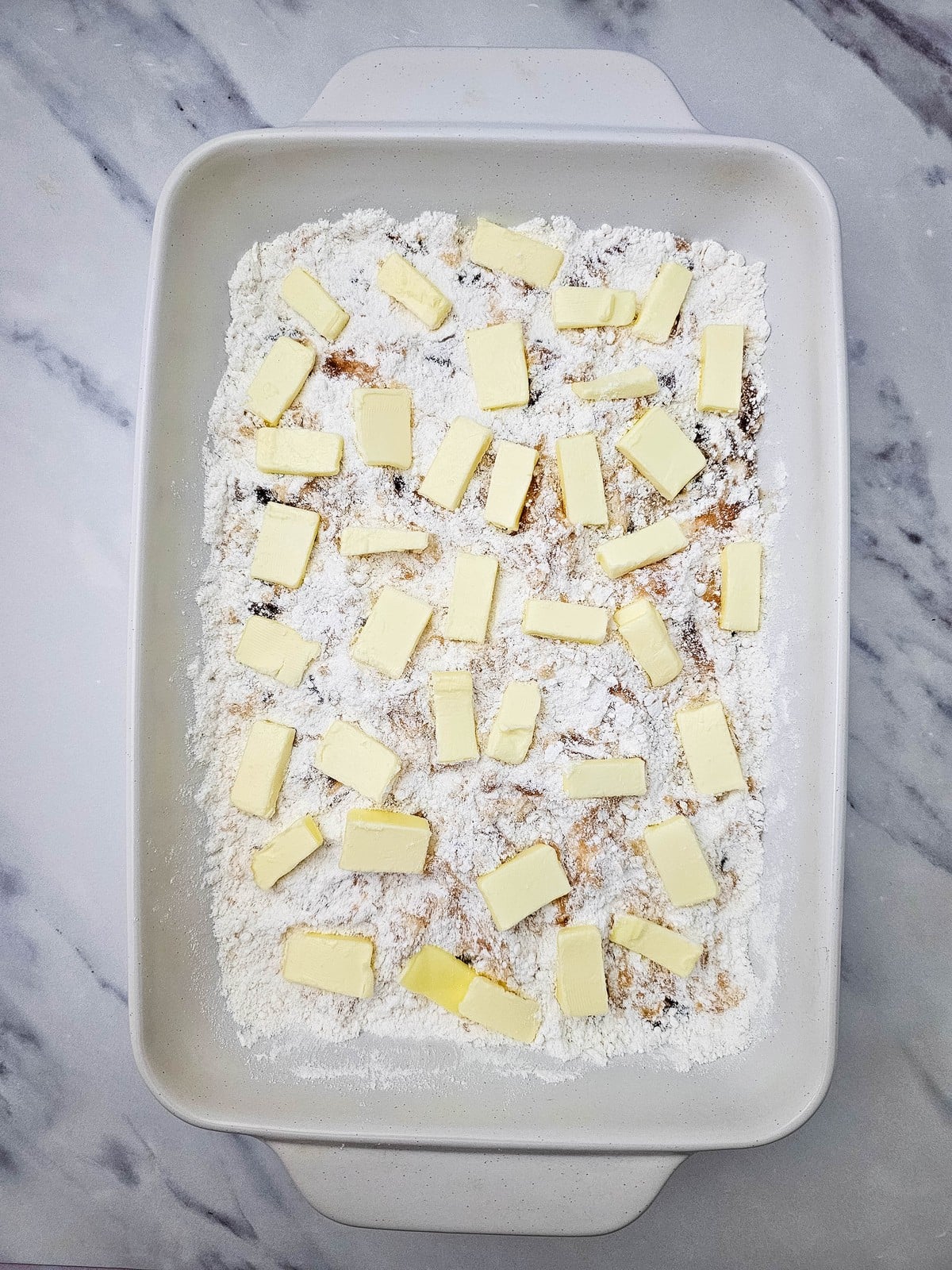 Pieces of butter scattered over the cake mix before baking