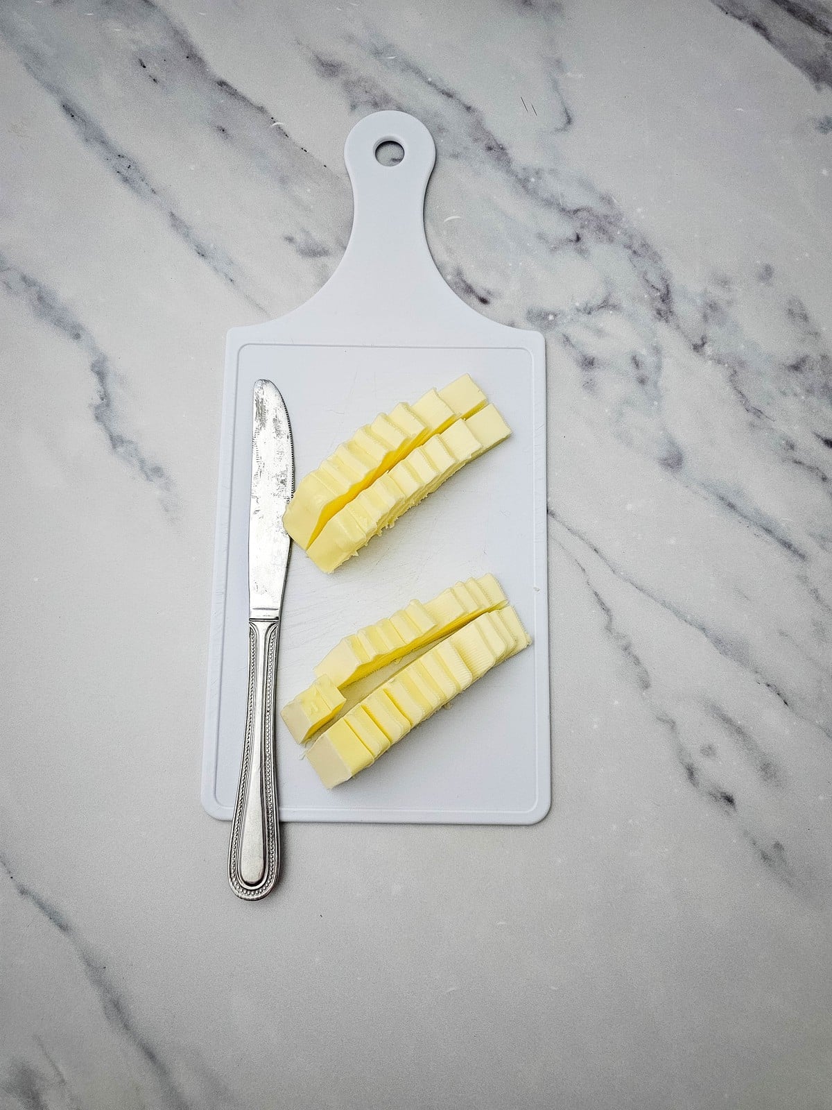 Butter cut into small pieces on a cutting board
