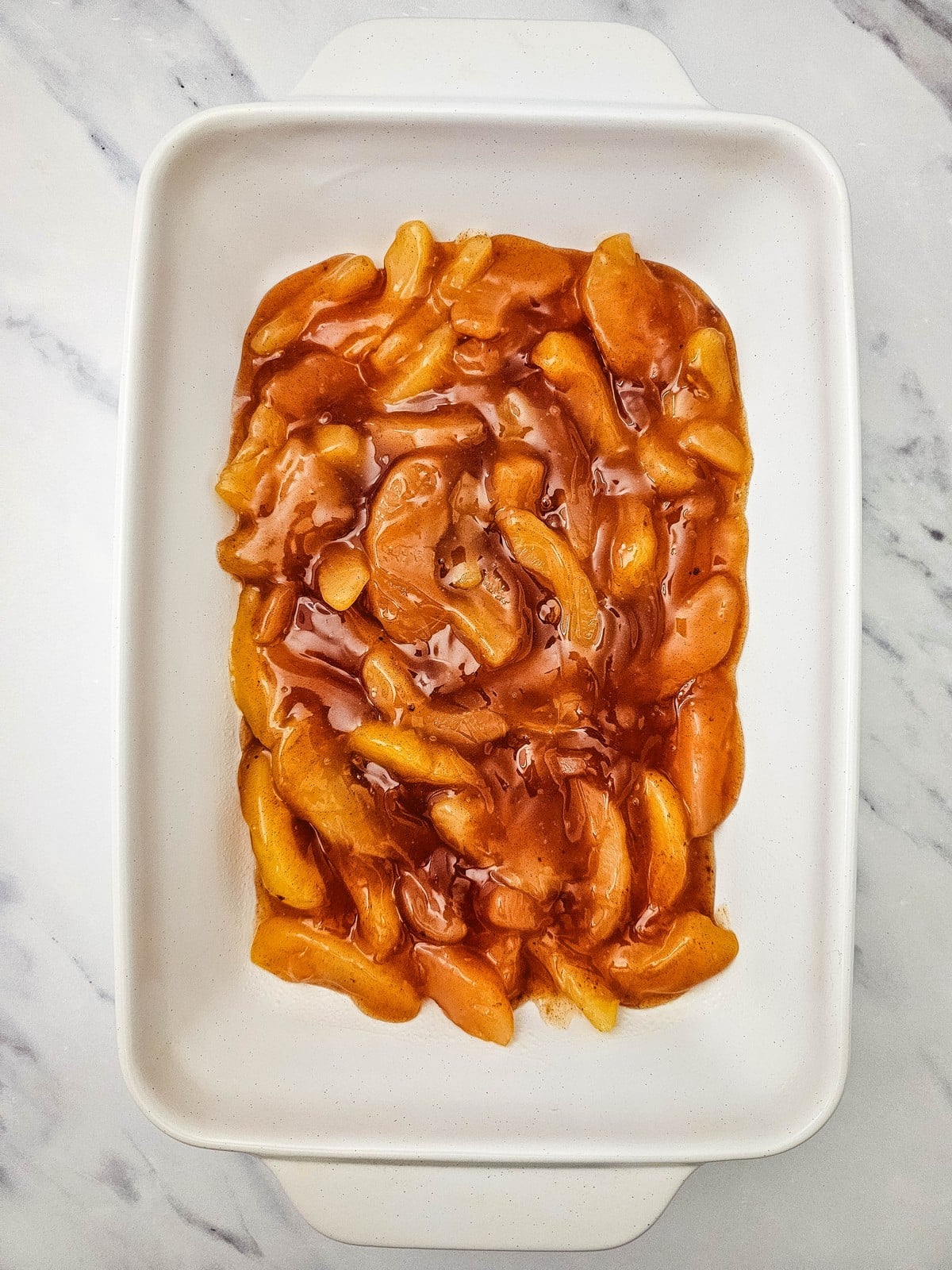Apple pie filling spread in a baking dish