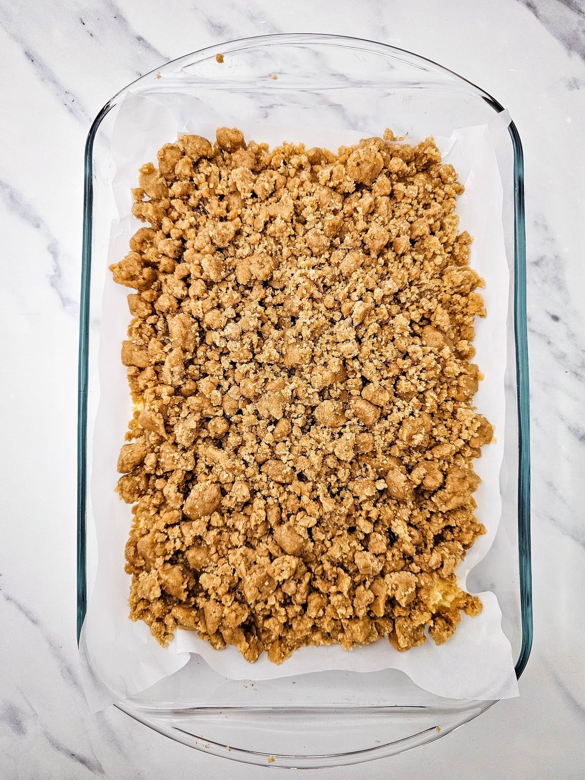 Cinnamon crumble sprinkled over the apple layer before baking