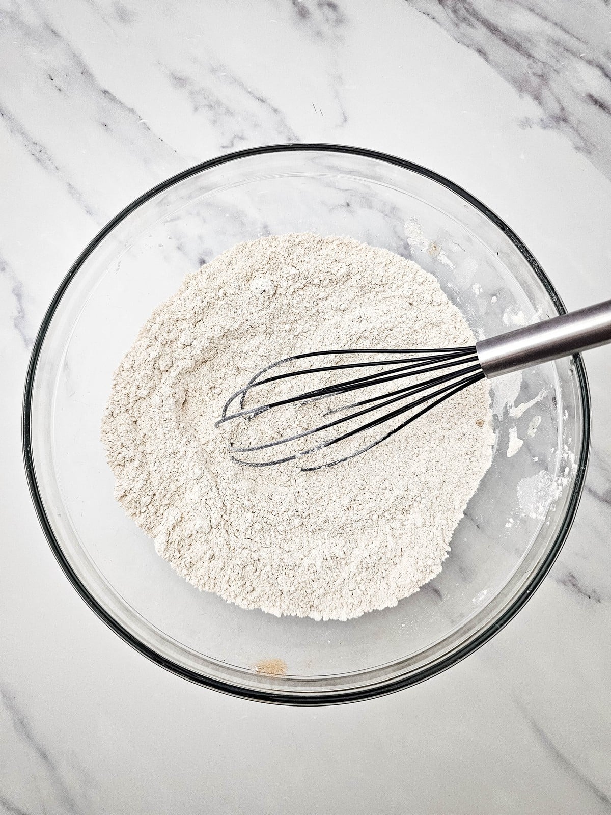 Whisked dry crumble mixture in a glass bowl