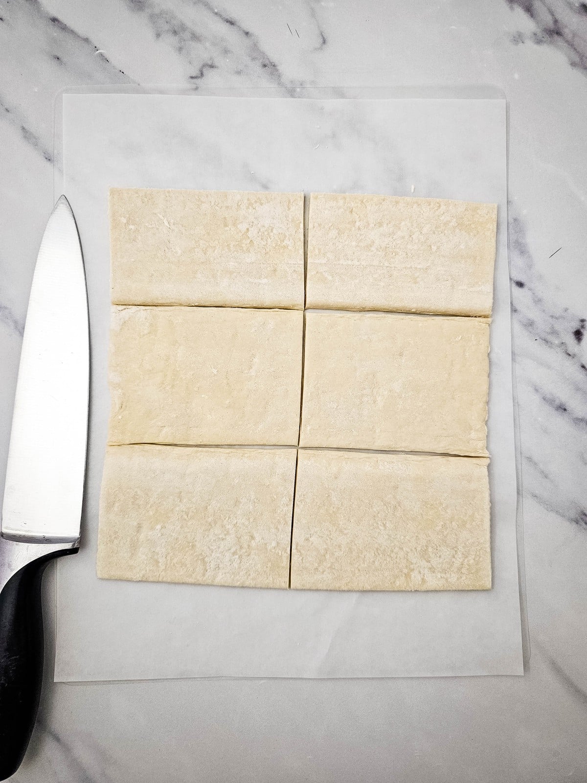 Cutting a puff pastry sheet into six rectangles with a knife