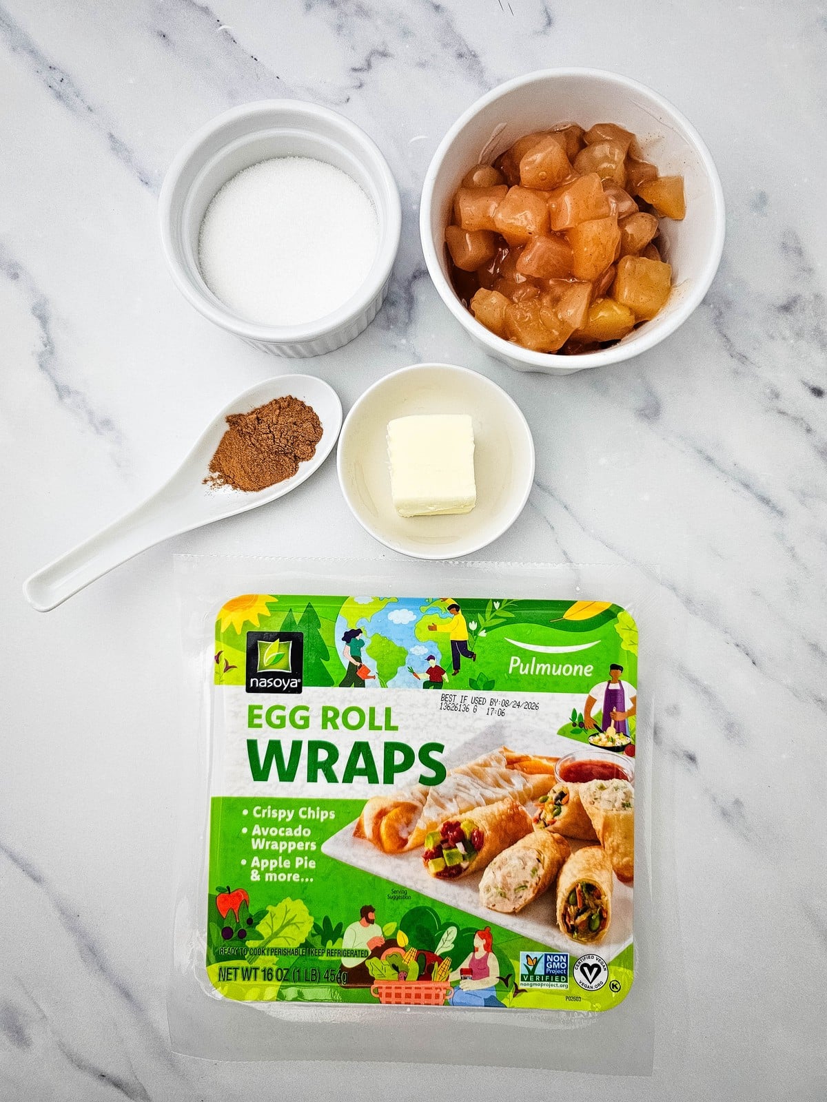 Ingredients for apple pie egg rolls: egg roll wrappers, apple pie filling, butter, sugar and cinnamon