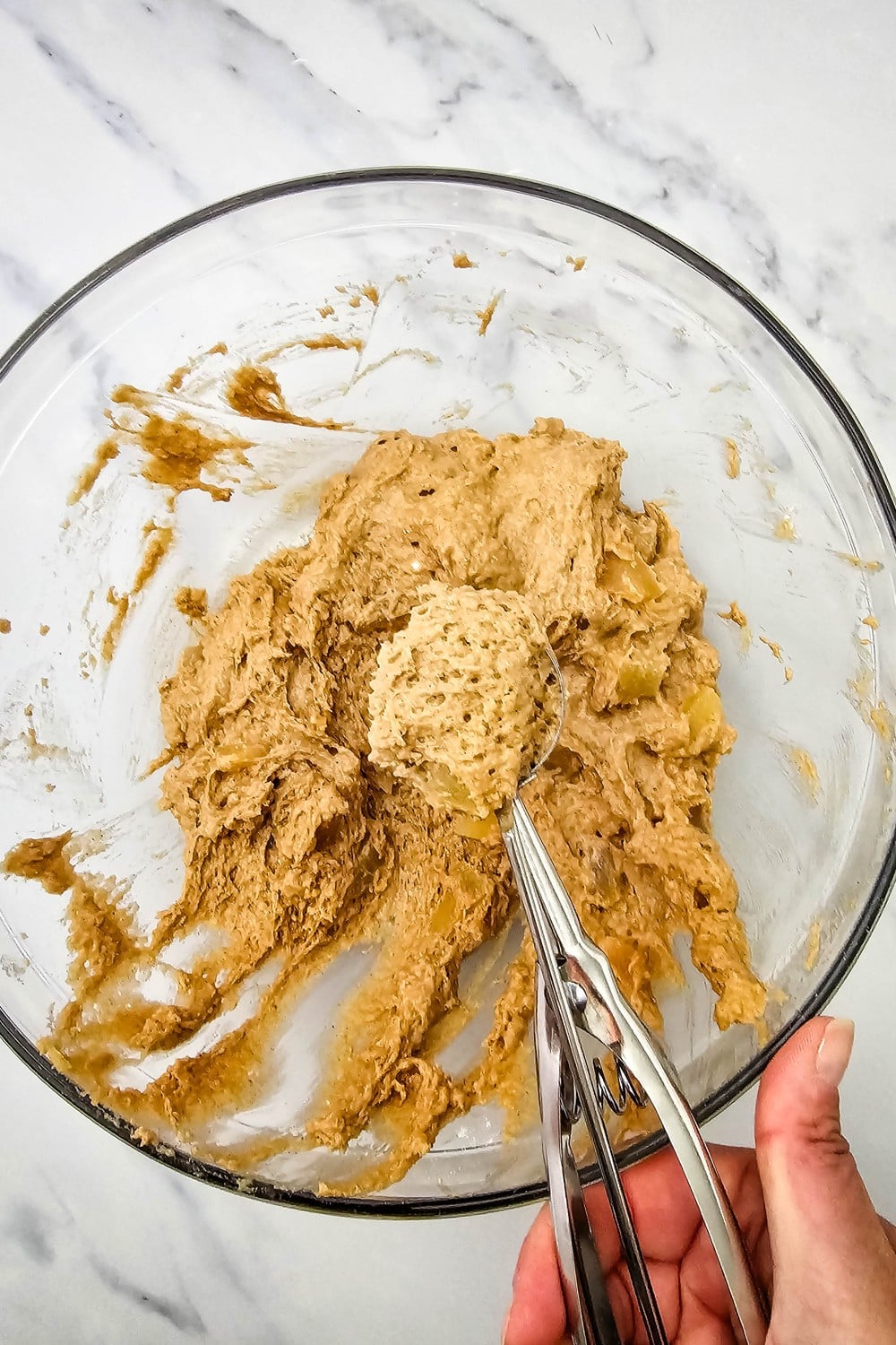 Scooping soft apple cookie dough with a cookie scoop