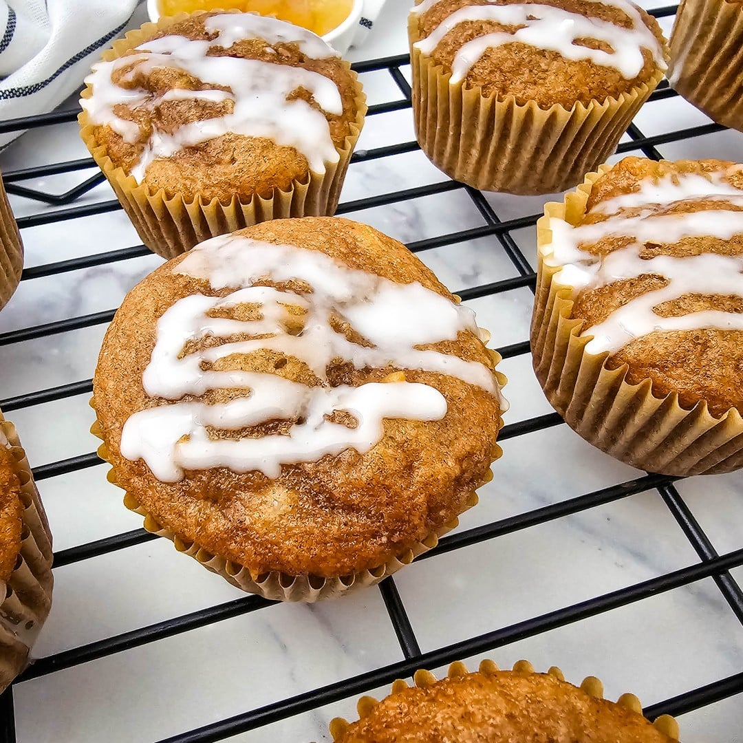 Glazed apple pie filling muffins in paper liners