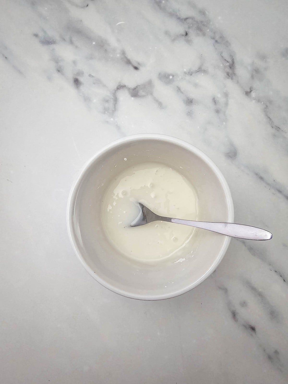 Powdered sugar glaze in a small white bowl