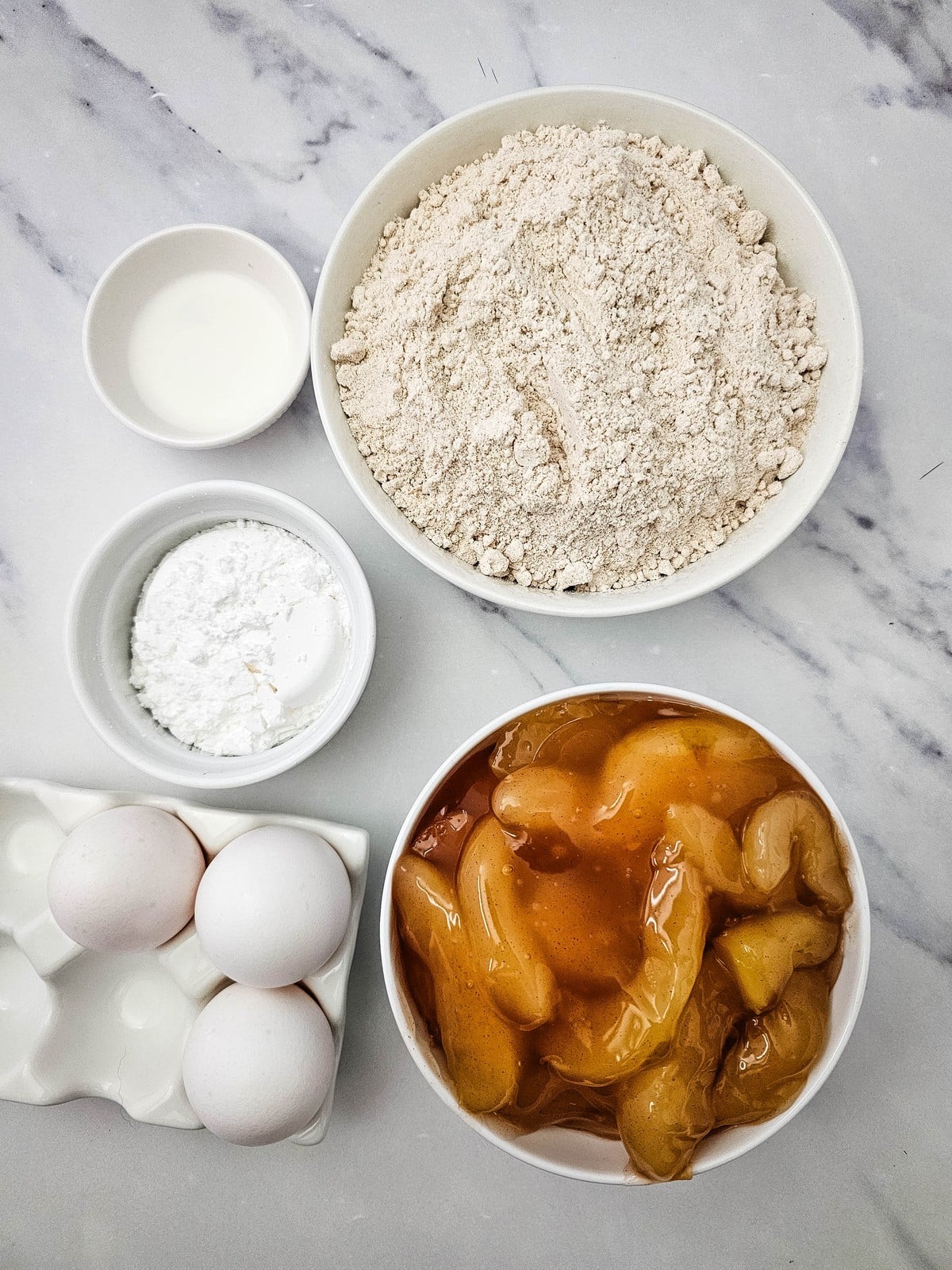 Ingredients for apple pie filling muffins: spice cake mix, apple pie filling, eggs, powdered sugar and milk