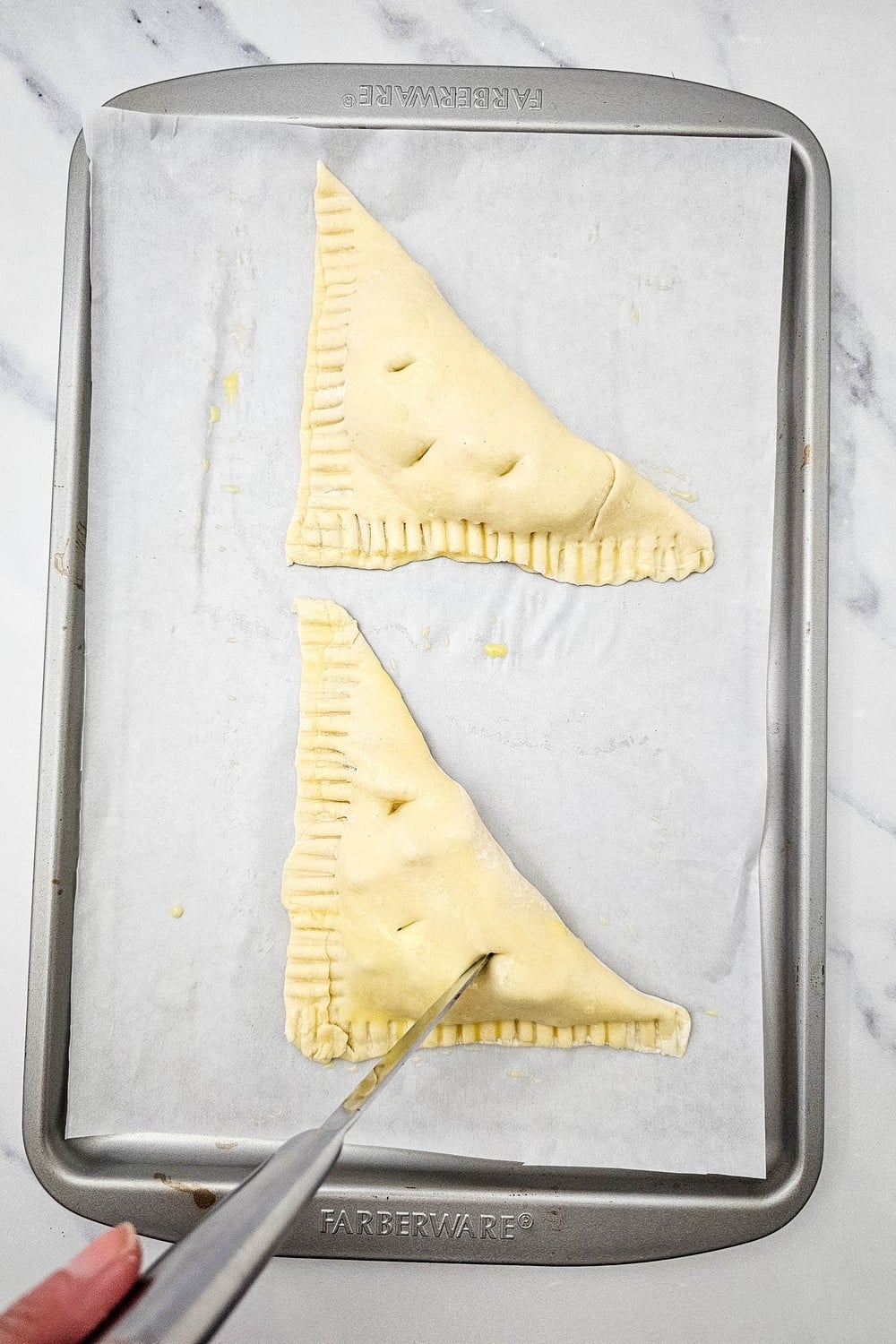 Cutting small vent slits in the tops of apple turnovers