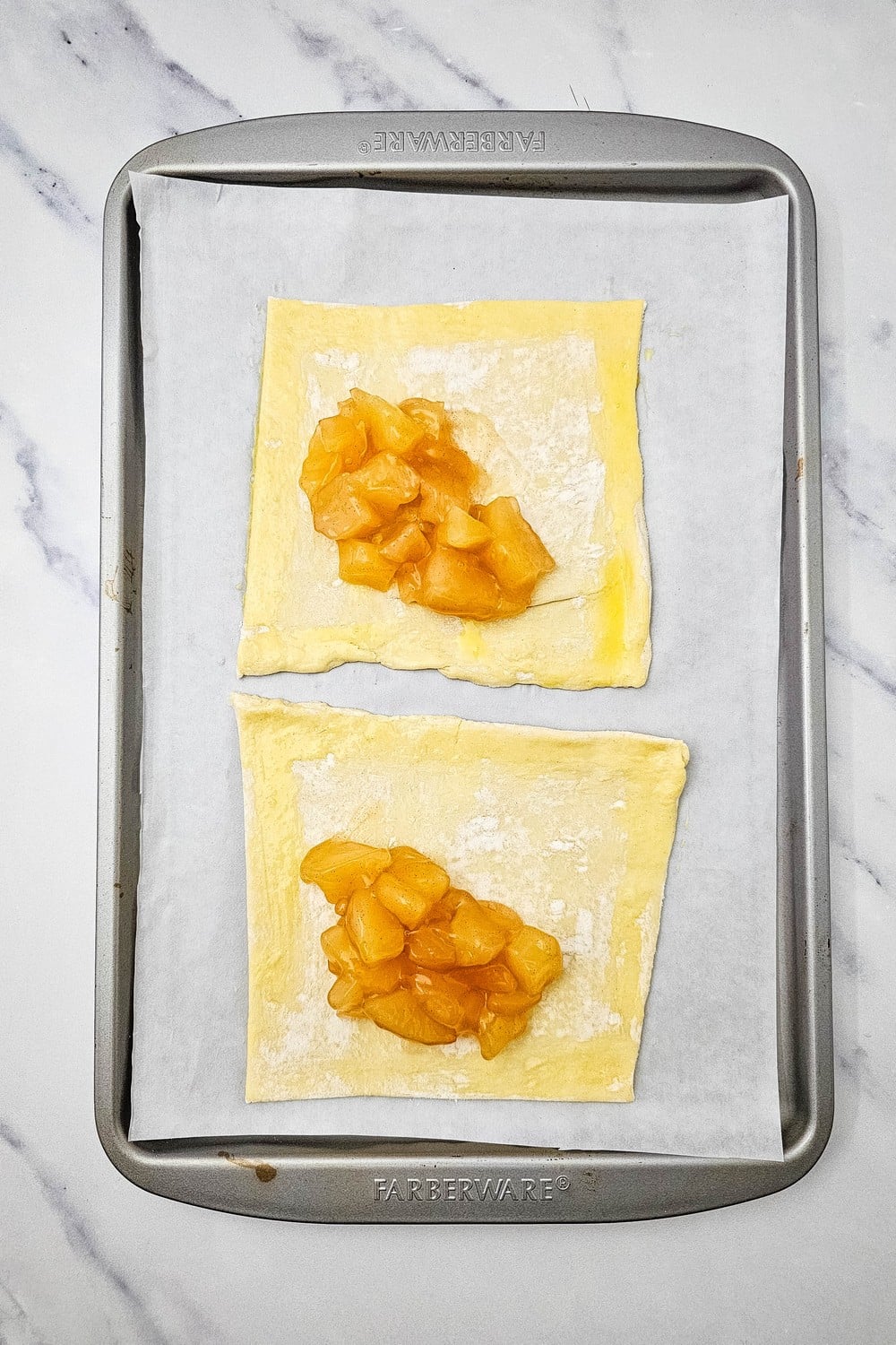 Apple pie filling spooned onto puff pastry squares