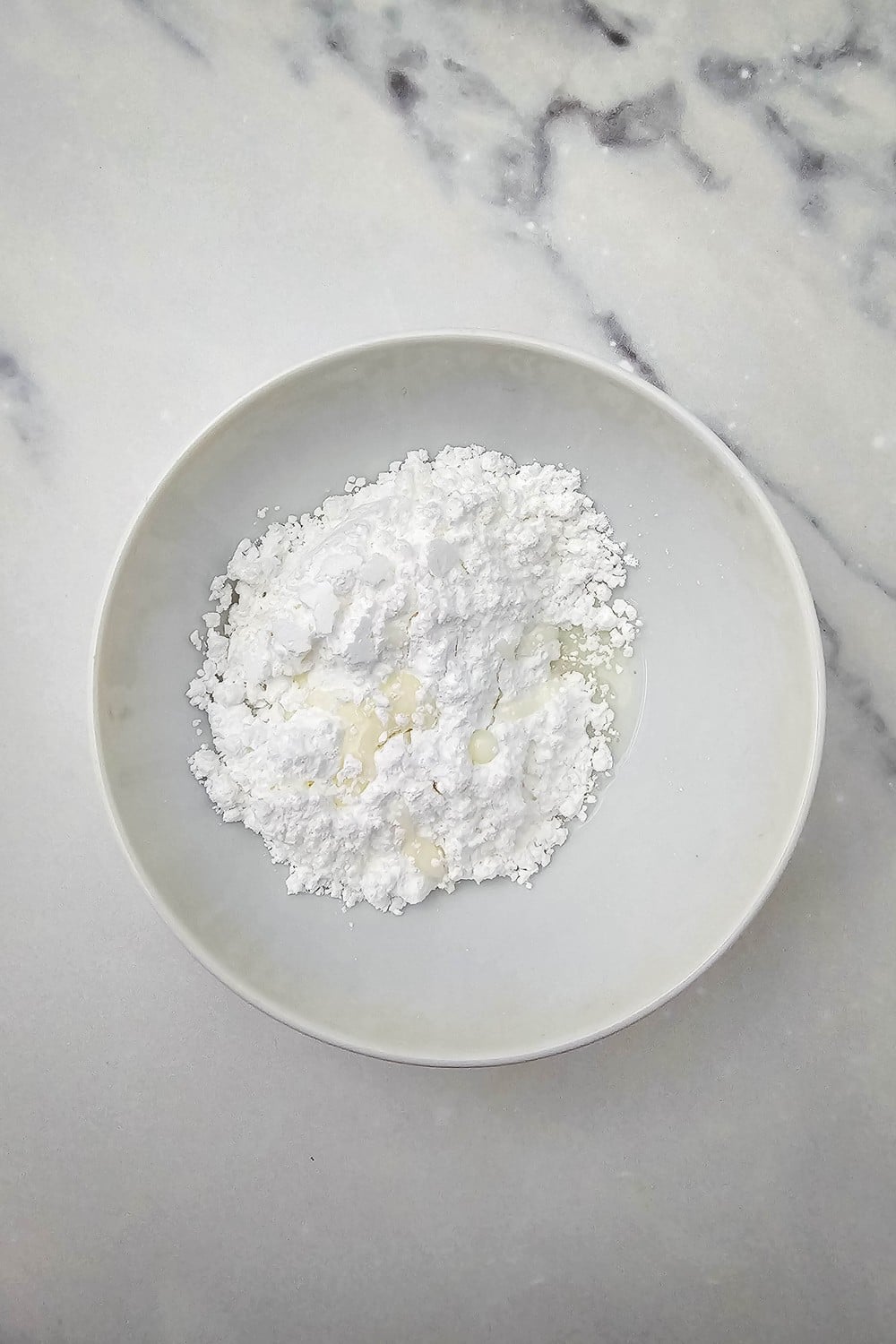 Powdered sugar and milk in a bowl for glaze