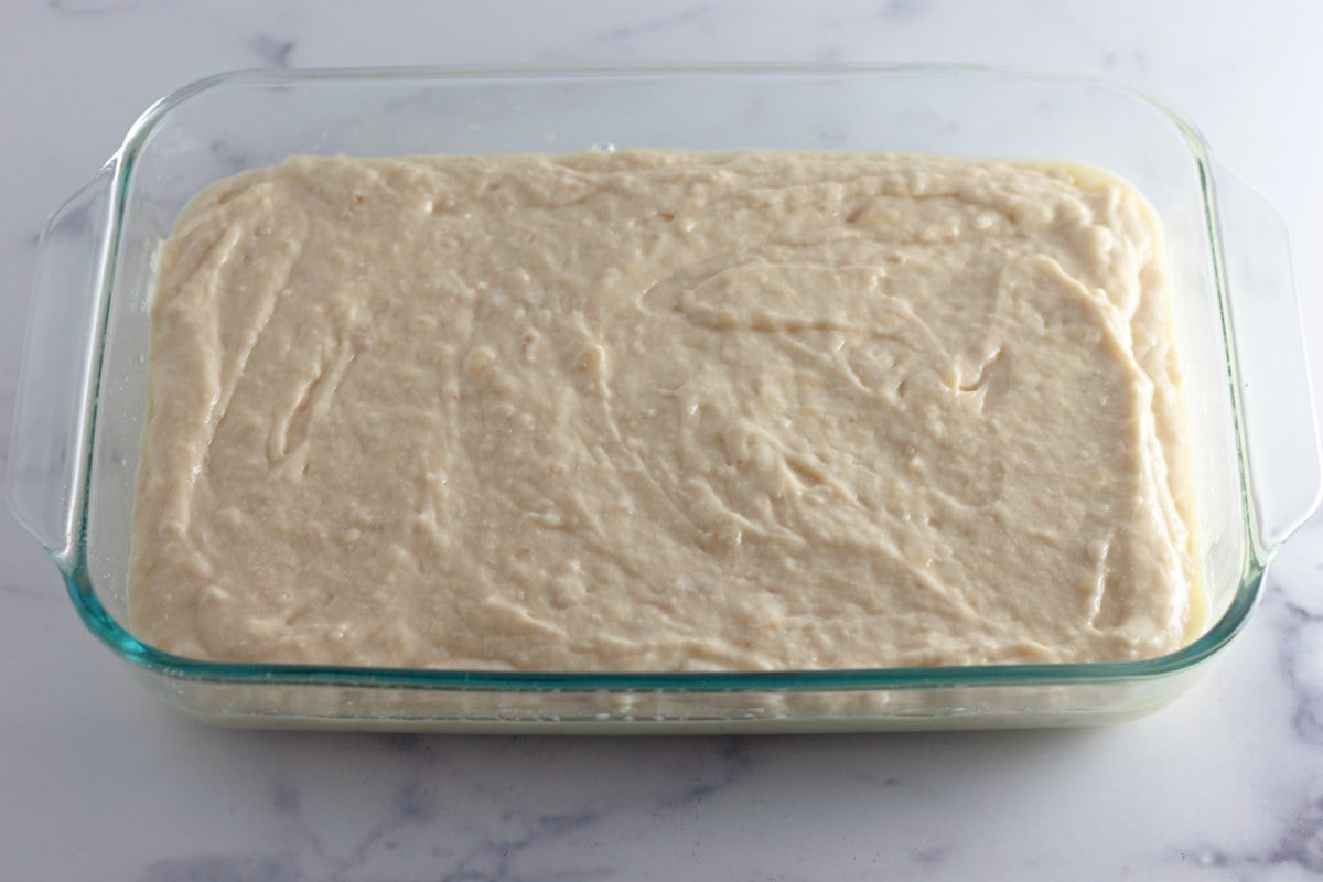Banana coffee cake batter spread edge to edge in a glass 9x13 baking pan