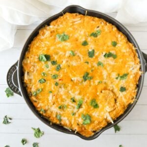 Overhead view of baked chicken enchilada dip in a cast iron skillet