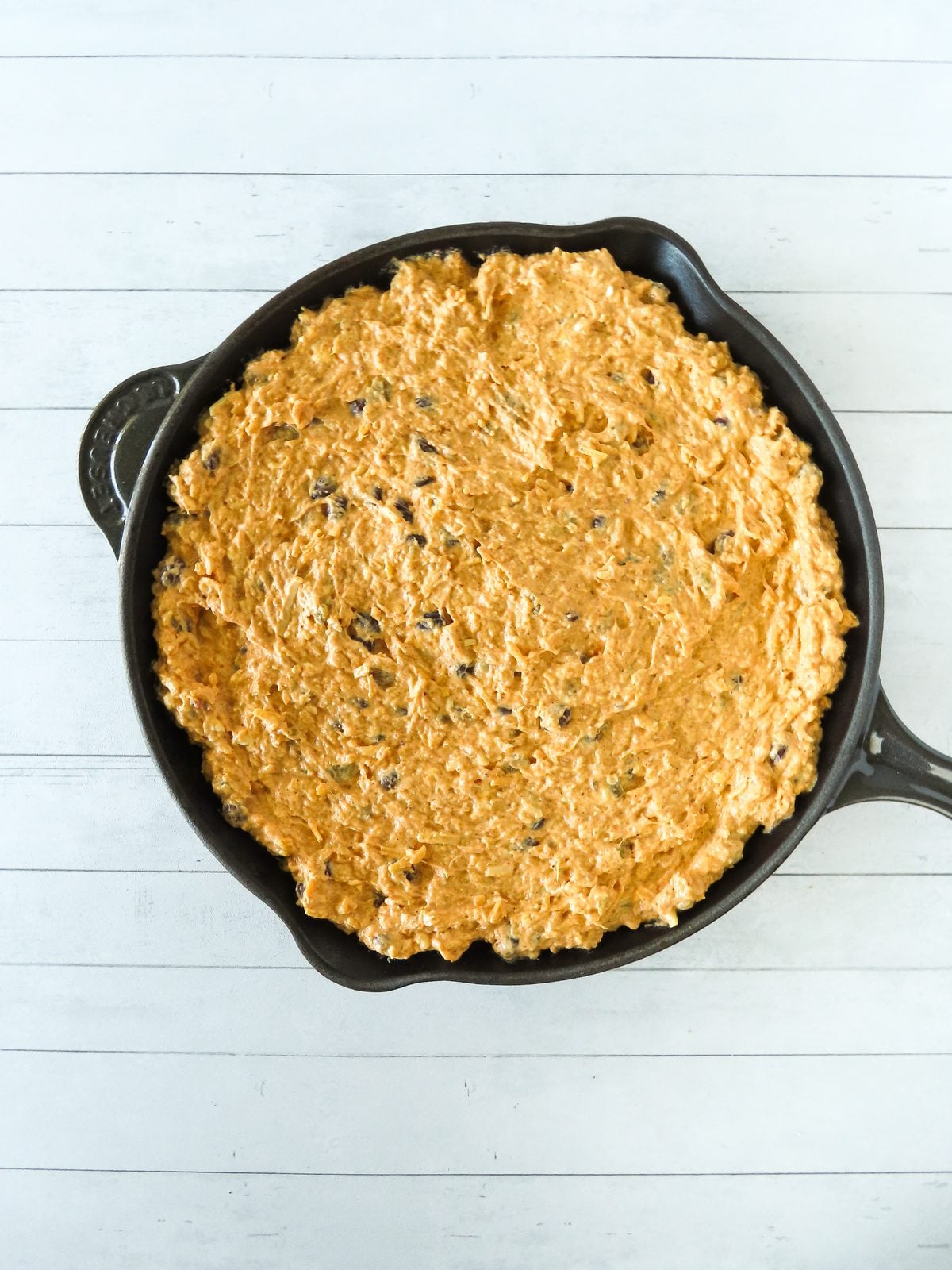 Enchilada dip mixture spread into an ovenproof skillet