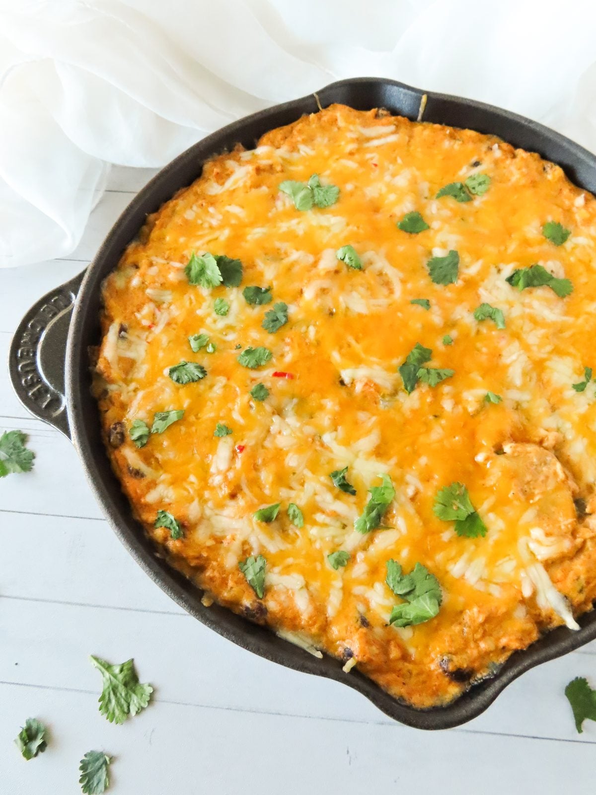 Chicken enchilada dip with a tortilla chip resting in the skillet