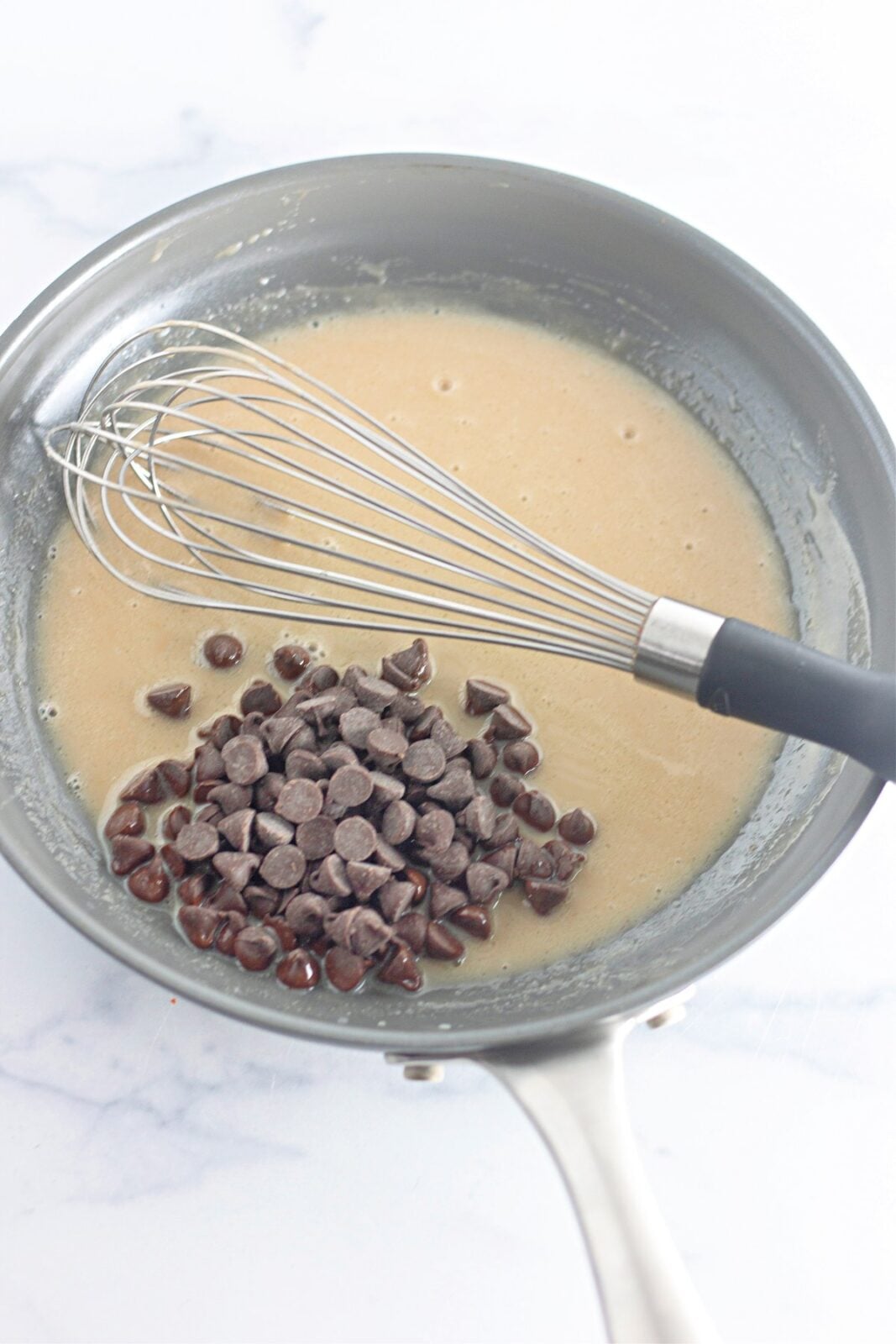 Chocolate chips added to the warm cream mixture in the skillet