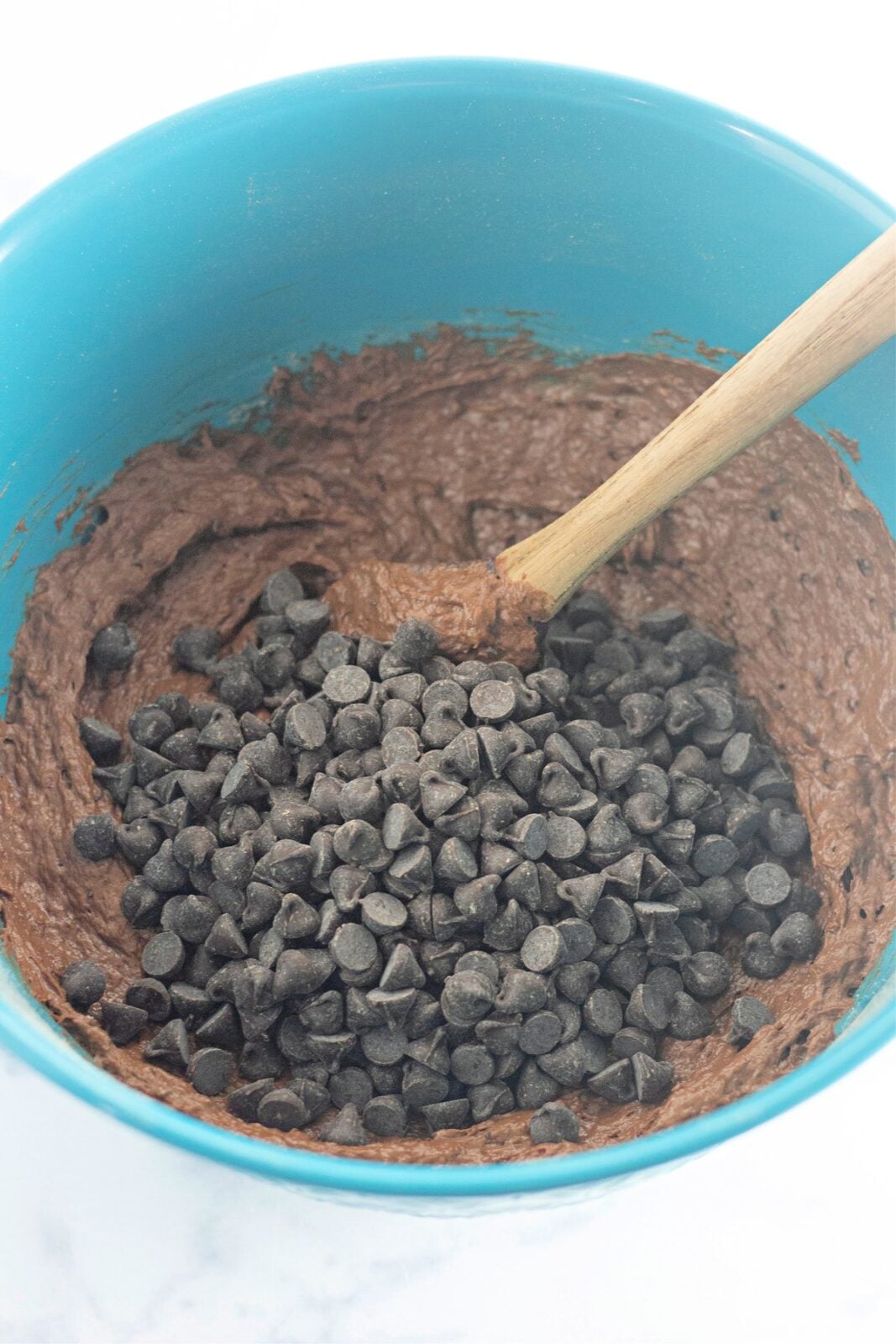 Folding semi-sweet chocolate chips into the chocolate banana bread batter