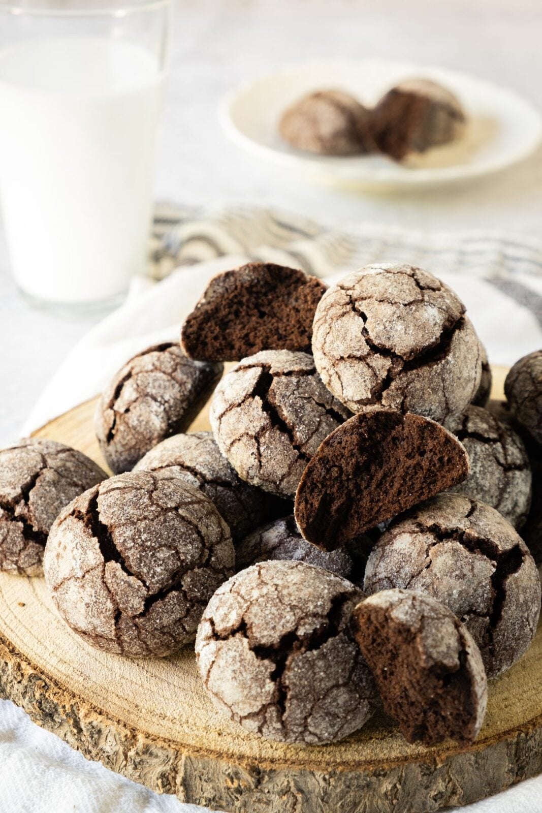 Chocolate snowball cookies on a wooden board served with a glass of milk
